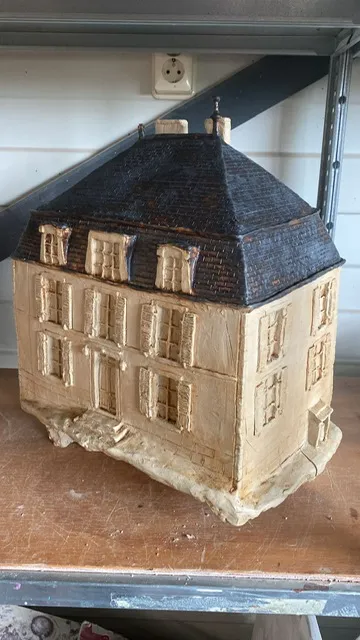 Beeld van een landhuis in klei